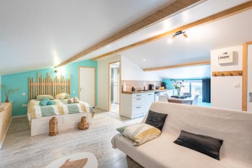 Cet appartement comprend une chambre avec un lit et un canapé ainsi qu'une cuisine. dans l'établissement Studio proche Marais Poitevin, à Oulmes