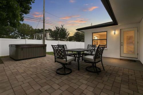 a patio with a table and chairs and a fence at Hot Tub - Pet Friendly - Mins to Beach - Sleeps 11 - Family in Clearwater