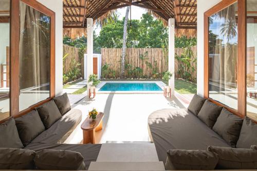 a living room with a couch and a swimming pool at SEACLUB Siargao in General Luna