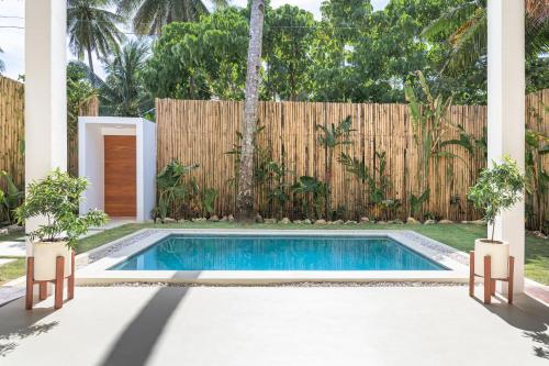 a swimming pool in a backyard with a fence at SEACLUB Siargao in General Luna