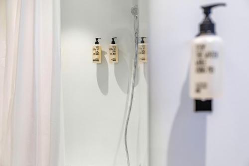 a white shower curtain with two bottles on a wall at Chalet Sonneck - Seefeld in Seefeld in Tirol