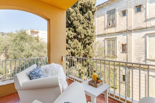 a balcony with a white couch and a view of a building at TheKeyStudio, La casa dei Delfini in Bordighera