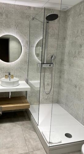 a bathroom with a shower and a sink at The Originals Boutique, Hôtel Le Pariou, Issoire in Issoire