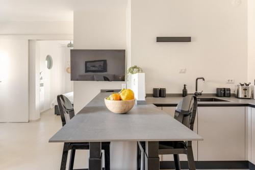 a kitchen with a table with a bowl of fruit on it at TheKeyStudio, La casa dei Delfini in Bordighera