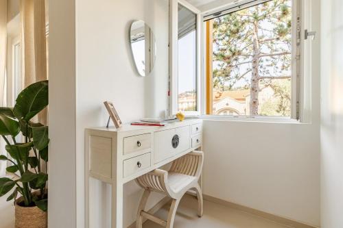 a dressing table and a chair in a room with a window at TheKeyStudio, La casa dei Delfini in Bordighera