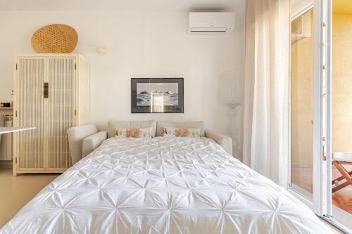 a bedroom with a large white bed in a room at TheKeyStudio, La casa dei Delfini in Bordighera