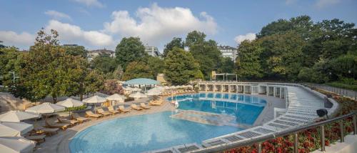 a large swimming pool with chairs and umbrellas at Hilton Istanbul Bosphorus in Istanbul