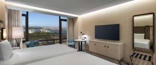 a hotel room with a bed and a flat screen tv at Hilton Istanbul Bosphorus in Istanbul