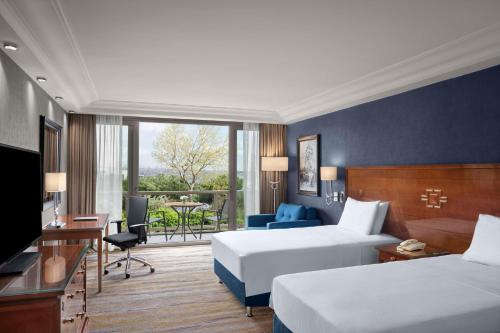 a hotel room with two beds and a balcony at Hilton Istanbul Bosphorus in Istanbul