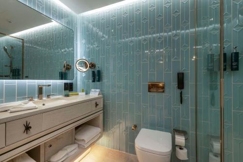 a bathroom with a toilet and a sink and a mirror at Hilton Istanbul Bosphorus in Istanbul