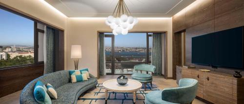 a living room with a couch and a flat screen tv at Hilton Istanbul Bosphorus in Istanbul