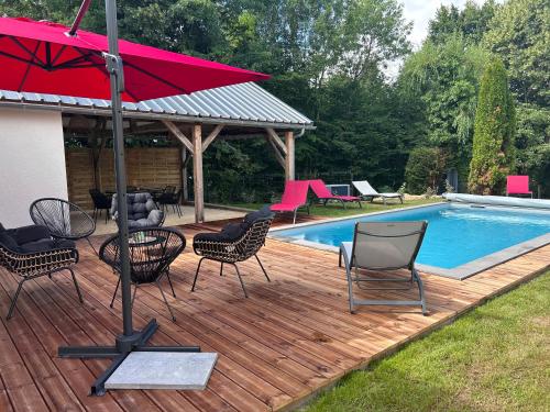 - une terrasse avec des chaises et un parasol à côté de la piscine dans l'établissement Eugenie, à Labrousse
