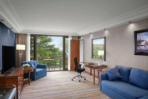 a living room with a blue couch and a desk at Hilton Istanbul Bosphorus in Istanbul