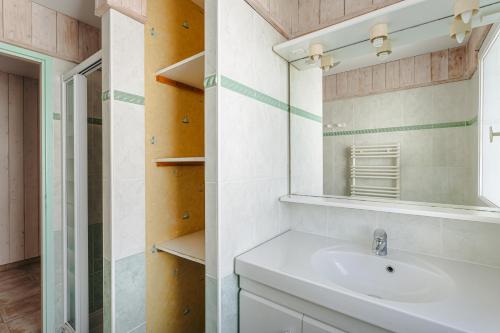 een badkamer met een wastafel en een spiegel bij L'Avocette in Le Bois-Plage-en-Ré