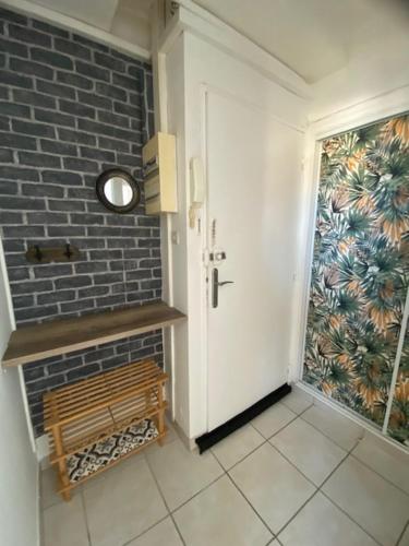 un couloir avec une porte blanche et un mur en briques dans l'établissement Le Myosotis Route des plages, à Narbonne