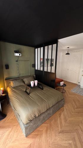 un grand lit dans une chambre avec parquet dans l'établissement Studio Cinéma Séjournez dans un Décor de Film, à Béziers