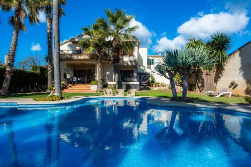 a swimming pool in front of a house with palm trees at Can Gual Inca in Inca