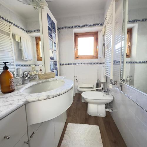 a white bathroom with a sink and a toilet at Chalet La Cometa in Sauze dʼOulx