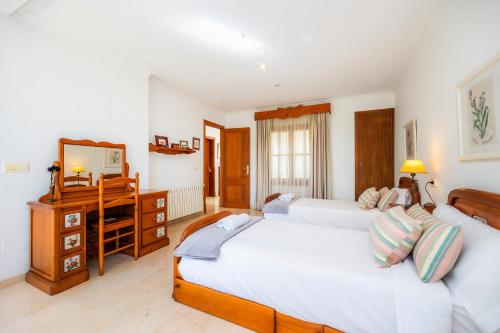 a bedroom with two beds and a desk with a mirror at Can Gual Inca in Inca