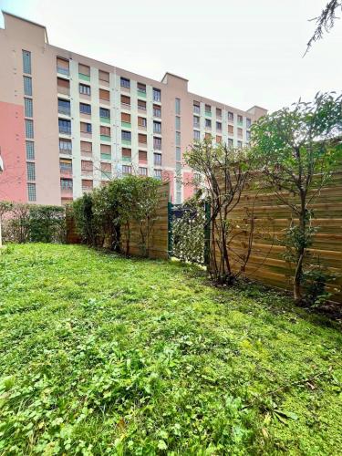 a grassy yard in front of a large building at T2 cosy avec parking - Goupama Stadium LDLC Arena in Décines-Charpieu