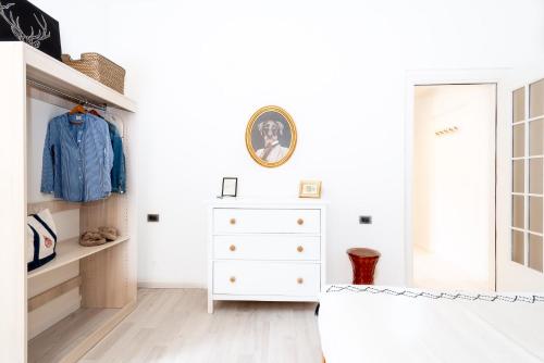 a white bedroom with a dresser and a mirror at Pied à terre Cernobbio in Cernobbio