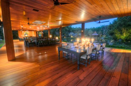 a wooden deck with a table and chairs on it at Tatvani Thailand - Private All-Inclusive Estate in Chiang Rai