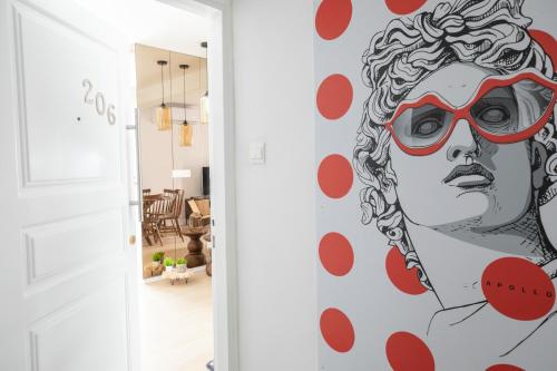 a mural of a woman with red glasses on a wall at Vivid Stays Chalkokondili in Nicosia