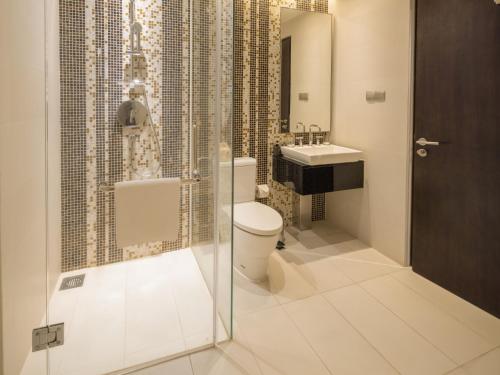 a bathroom with a toilet and a sink at The Costa Nha Trang Residences in Nha Trang