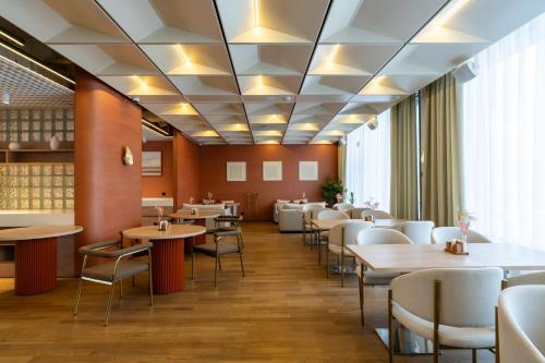una sala da pranzo con tavoli e sedie di Renion City Hotel a Almaty