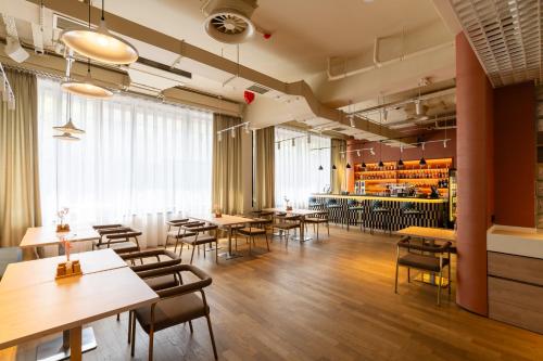 un ristorante con tavoli e sedie e un bar di Renion City Hotel a Almaty