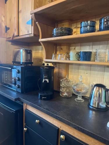 un comptoir de cuisine avec une cafetière et de la vaisselle dans l'établissement La Petite Maison, à Gérardmer