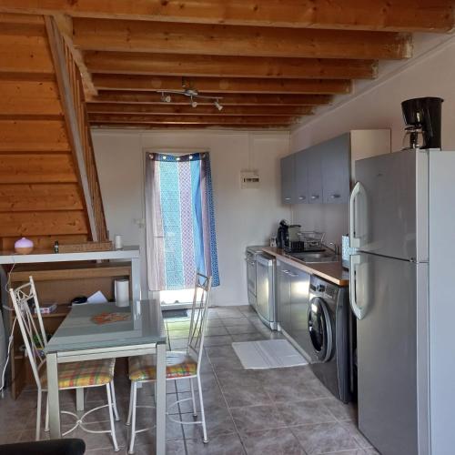 une cuisine avec une table et un réfrigérateur dans l'établissement Le Rosalbin, à Jupilles