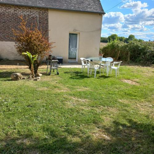 - une table et des chaises dans la cour d'une maison dans l'établissement Le Rosalbin, à Jupilles