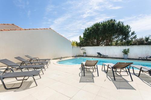 un patio avec des chaises et une piscine dans l'établissement Pingettes 4, au Bois-Plage-en-Ré