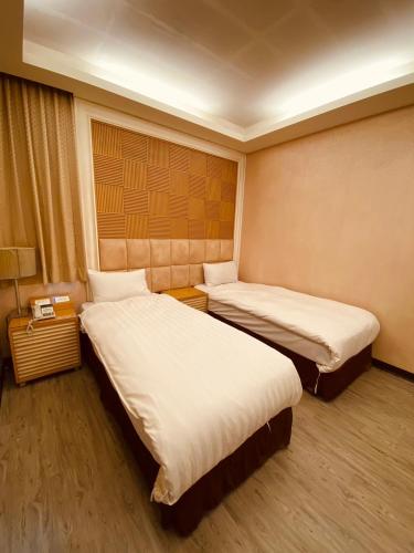 a room with two beds in a hotel room at AOIKE Hot Spring Hotel in Jiaoxi