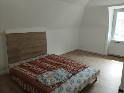 a bed in a room with a wooden floor at Appartement Vic-sur-Cère in Vic-sur-Cère