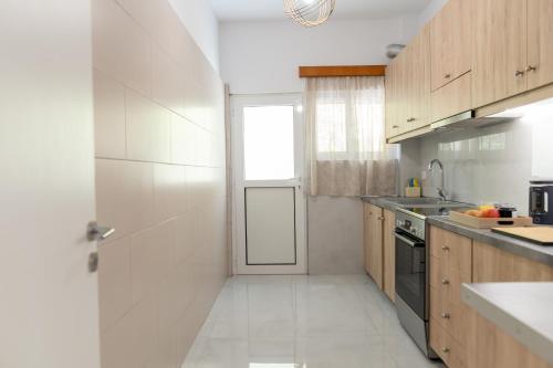 a kitchen with white walls and wooden cabinets at Natalia's Nest in Ampavris