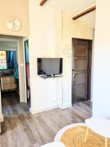 a living room with a flat screen tv on a wall at Appartement T3 - 650m de la plage in Le Grau-dʼAgde