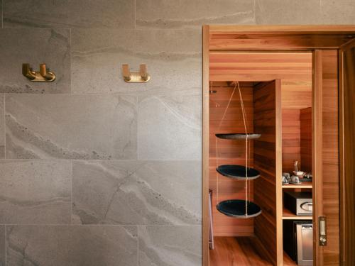 a bathroom with a stone wall and a wooden cabinet at PHA NYA RESIDENCE in Luang Prabang