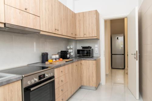 a kitchen with wooden cabinets and a stove top oven at Natalia's Nest in Ampavris