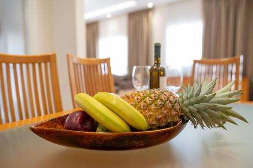 a bowl of fruit on a table with a bottle of wine at Natalia's Nest in Ampavris