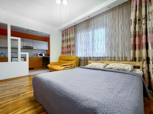 a bedroom with a bed and a couch in it at 05 Апартаменты в центре города - выбор для туриста и деловых поездок in Almaty