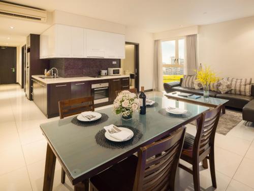 a kitchen and living room with a table and chairs at The Costa Nha Trang Residences in Nha Trang