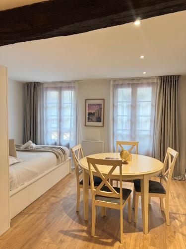 une chambre avec un lit, une table et des chaises dans l'établissement Le petit Vasselot, Centre de Rennes, à Rennes