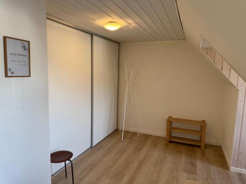 an empty room with a staircase and a chair at Stor lejlighed tæt på Saltum in Brønderslev