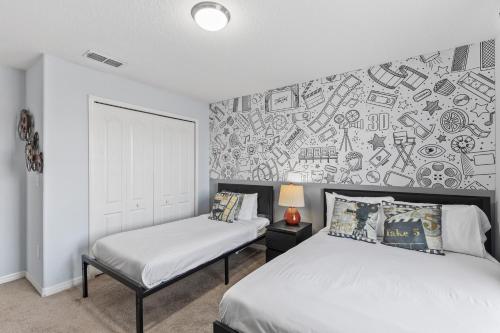 a bedroom with two beds and a wall covered in stickers at 8893 Candy Palm Road in Kissimmee