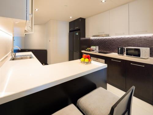 a kitchen with a counter with a bowl of fruit on it at The Costa Nha Trang Residences in Nha Trang