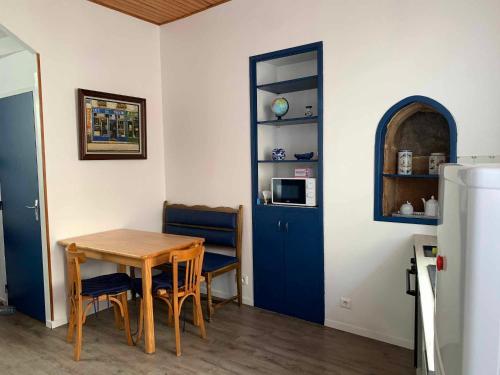 une salle à manger avec une table et une porte bleue dans l'établissement Maison en plein coeur du centre historique, à Malestroit
