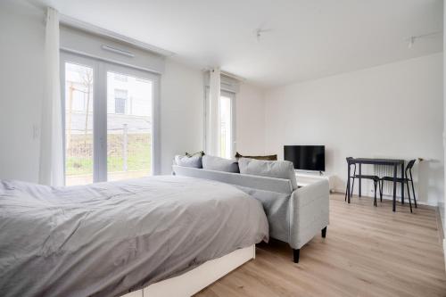 une chambre blanche avec un lit et une chaise dans l'établissement Cosy studio à Rosny-sous-Bois, à Rosny-sous-Bois
