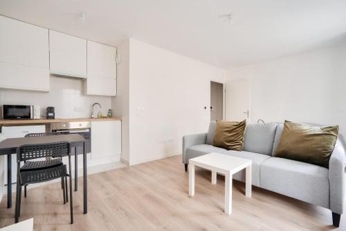 un salon avec un canapé et une table dans l'établissement Cosy studio à Rosny-sous-Bois, à Rosny-sous-Bois